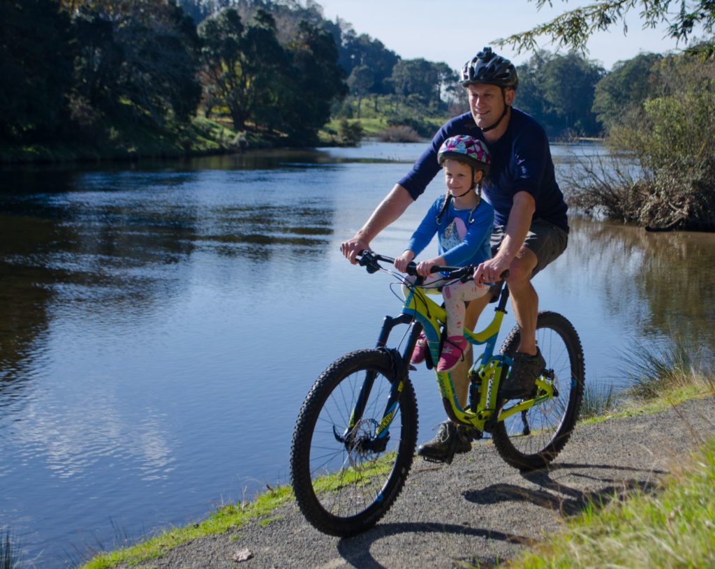 Father and Son Cycling Along the River's Edge
